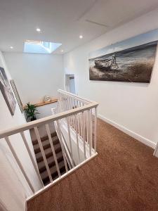 a staircase in a house with a painting on the wall at Jasper Apartment in Lyme Regis