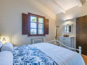 Schlafzimmer mit einem blauen und weißen Bett und einem Fenster in der Unterkunft Holiday Home Casale L'Uliveta by Interhome in Canneto