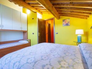 um quarto com uma cama grande e paredes amarelas em Holiday Home Belvedere - BLU101 by Interhome em Bagni di Lucca