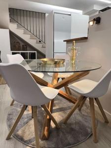 a glass dining table with white chairs in a room at Loft en Barcelona in Barcelona