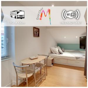 una camera con letto, tavolo e sedie di Stop Chez M Select Sense # Qualité # Confort # Simplicité a Saint-Fons