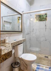 a white bathroom with a toilet and a shower at Pousada Belvedere da Serra in Serra do Cipo