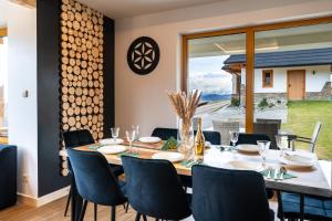 jadalnia ze stołem i krzesłami oraz dużym oknem w obiekcie Czorsztyn Ski&Sail Aparthouse w mieście Maniowy
