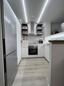 cocina con armarios blancos y nevera en Loft en Barcelona, en Barcelona
