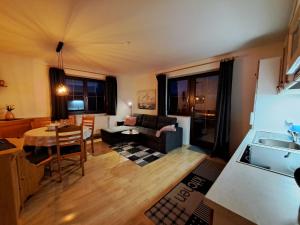 cocina y sala de estar con sofá y mesa en Apartment App- Helga - FIB220 by Interhome, en Fieberbrunn