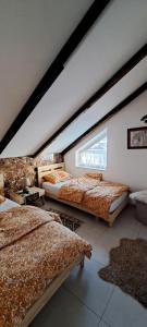 a attic bedroom with three beds and a window at The house of dreams in Shkodër