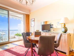 een eetkamer met een tafel en stoelen en een televisie bij Apartment La Floride Promenade des Anglais by Interhome in Nice
