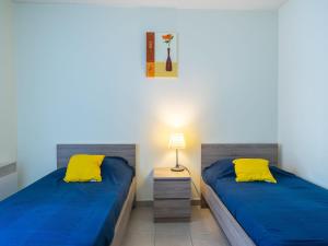 ポンタィヤックにあるApartment La Plage by Interhomeの黄色い枕2つが備わる客室内のベッド2台