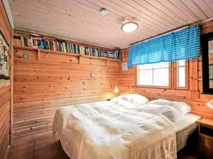 a bedroom with a bed in a wooden wall at Holiday Home Marjatan mökki by Interhome in Ylikyro
