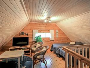 a attic room with a bed and a television at Holiday Home Marjatan mökki by Interhome in Ylikyro