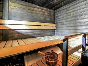 a sauna with a bench and a bucket in it at Holiday Home Marjatan mökki by Interhome in Ylikyro