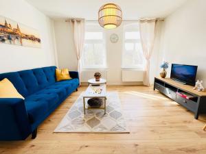 a living room with a blue couch and a tv at Twenty Five Apartment in Heidenau