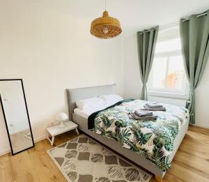 Schlafzimmer mit einem Bett und einem Spiegel in der Unterkunft Twenty Five Apartment in Heidenau