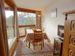 ein Esszimmer mit einem Tisch und einem großen Fenster in der Unterkunft Apartment Les Mischabels-2 by Interhome in Crans-Montana