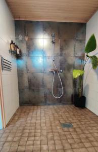 a shower in a bathroom with a tile floor at Nordic Villa with private sledding hill in Rovaniemi