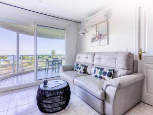 a living room with a couch and a view of the ocean at Apartment Le Frémont by Interhome in Nice