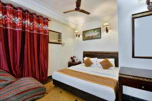 a hotel room with a bed and a couch at Hotel By Yellow Revels Plum in New Delhi