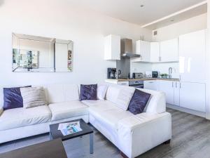 a white living room with a white couch and a kitchen at Studio La Joconde by Interhome in Nice