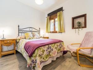 1 dormitorio con 1 cama y 1 silla en Holiday Home Potes Viñon by Interhome, en Tama