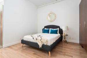 1 dormitorio con cama con almohadas azules y espejo en Le Merrill Boutique Hotel, en Montreal