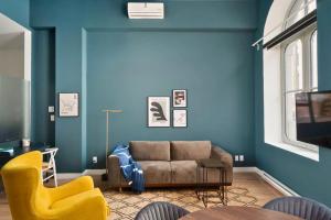 sala de estar con sofá y pared azul en Le Merrill Boutique Hotel, en Montreal
