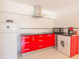 a kitchen with red cabinets and a washing machine at Apartment Les Collines de valescure by Interhome in Saint-Raphaël