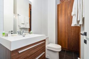 a bathroom with a white sink and a toilet at Le Merrill - Vieux Montréal in Montreal