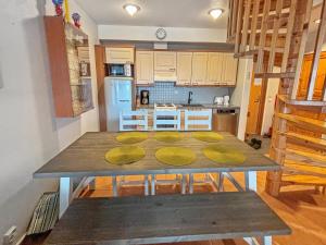 a kitchen with a wooden table with yellow plates on it at Holiday Home Aquahovi b5 by Interhome in Sirkka