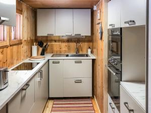 uma cozinha com armários brancos e uma pia em Holiday Home Ylikitkajärvi- kesäkumpu by Interhome em Orjasniemi mais 16 fotografias
