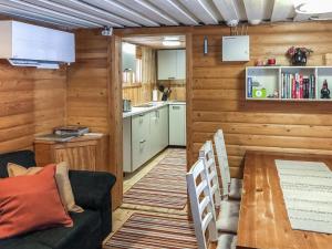 uma sala de estar com um sofá e uma mesa e uma cozinha em Holiday Home Ylikitkajärvi- kesäkumpu by Interhome em Orjasniemi