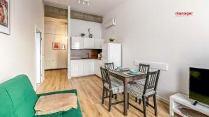 a living room with a table and chairs and a kitchen at Artystyczny in Racibórz