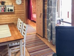 uma sala de jantar com mesa e cadeiras de madeira em Holiday Home Ylikitkajärvi- kesäkumpu by Interhome em Orjasniemi