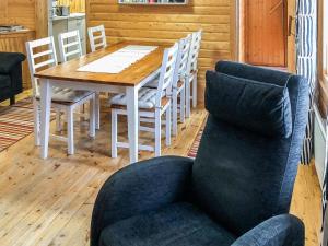 uma sala de jantar com uma mesa e uma cadeira em Holiday Home Ylikitkajärvi- kesäkumpu by Interhome em Orjasniemi