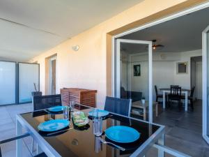 a dining room with a table with blue plates on it at Apartment Le Jardin du Loderi-2 by Interhome in Bormes-les-Mimosas