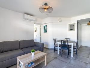 a living room with a couch and a table at Apartment Le Jardin du Loderi-2 by Interhome in Bormes-les-Mimosas