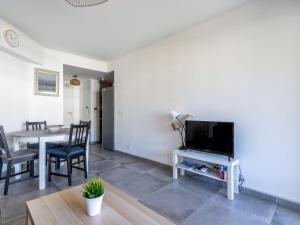 - un salon avec une télévision et une table avec des chaises dans l'établissement Apartment Le Jardin du Loderi-2 by Interhome, à Bormes-les-Mimosas