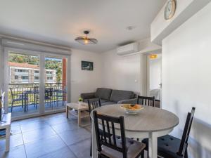 a living room with a table and a couch at Apartment Le Jardin du Loderi-2 by Interhome in Bormes-les-Mimosas