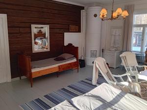 a bedroom with a bed and two white chairs at Holiday Home Elfvik by Interhome in Porvoo