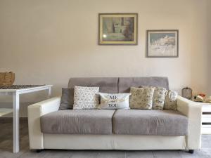 ein Sofa mit Kissen darauf im Wohnzimmer in der Unterkunft Apartment D3 - 6 by Interhome in Marinella
