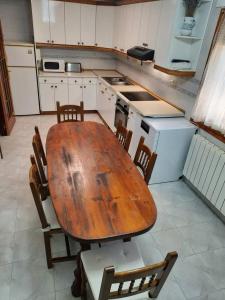 Il comprend une cuisine avec une table et des chaises en bois. dans l'établissement 5 bedrooms house with wifi at Alera, à Sádaba