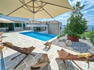 uma piscina com duas cadeiras e um guarda-sol em Villa Mladenka by Interhome em Jesenice