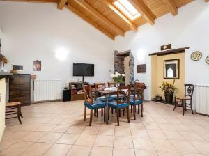 comedor con mesa, sillas y TV en Casa Vacanza La Fontanella, en Piedimonte Etneo