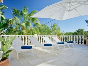 a group of white chairs and an umbrella on a patio at Villa Villa Ewa by Interhome in Jávea