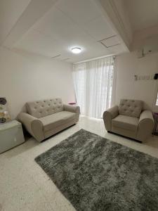 uma sala de estar com dois sofás e um tapete em Dagang Homestay em Ampang