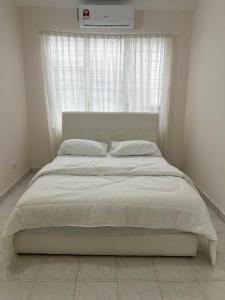 uma cama num quarto com uma janela e ar condicionado em Dagang Homestay em Ampang