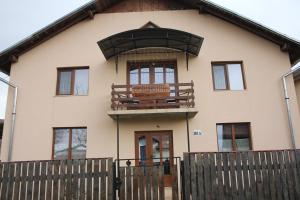 a house with a balcony on top of it at Casa Linistita in Chişcău