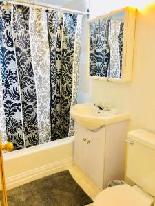 a bathroom with a sink and a shower curtain at Stylish Montreal Apartment: Comfortable Stay in the Golden Square Mile in Montreal