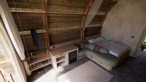 um pequeno quarto com uma cama e uma televisão em OYA - Wellness Eco Resort & Retreat em Jamao al Norte