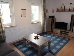 un salon avec une table basse et une télévision dans l'établissement Apartment Nordlicht by Interhome, à Bremerhaven