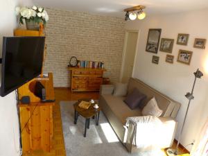 ein Wohnzimmer mit einem Sofa und einem TV in der Unterkunft Apartment Résidence du Golf by Interhome in Crans-Montana